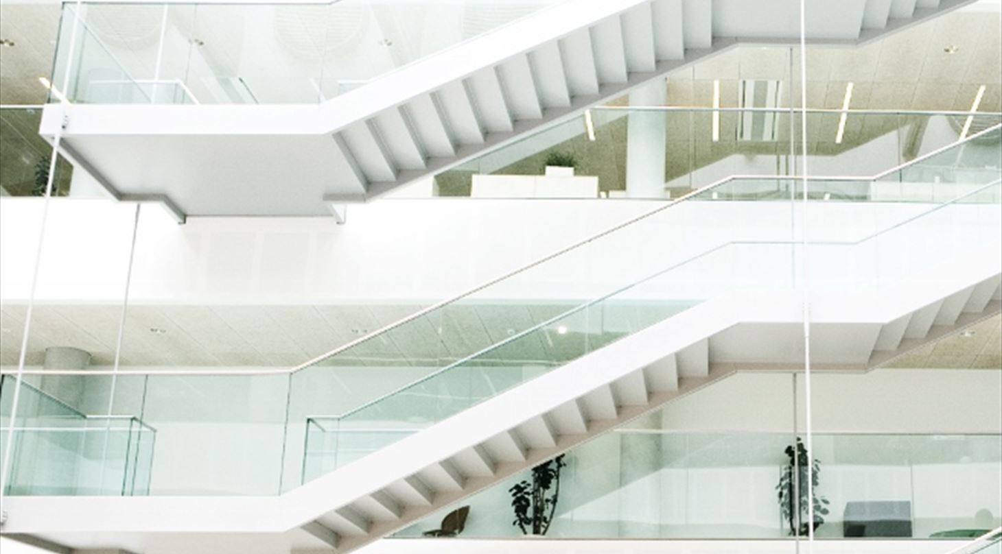 På billedet er der to hvide trapper indvendig i en stor bygning,